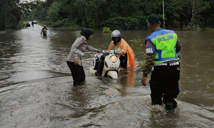 Personil Polres Merauke Membantu Warga terdampak banjir di jalan trans Papua di Distrik Eligobel