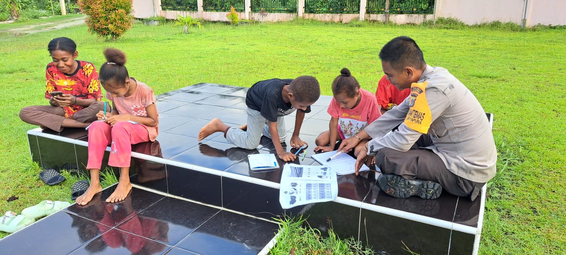 Bhabinkamtibmas Ajarkan Anak – anak Baca Tulis di Halaman Mapolsek Nimbokrang