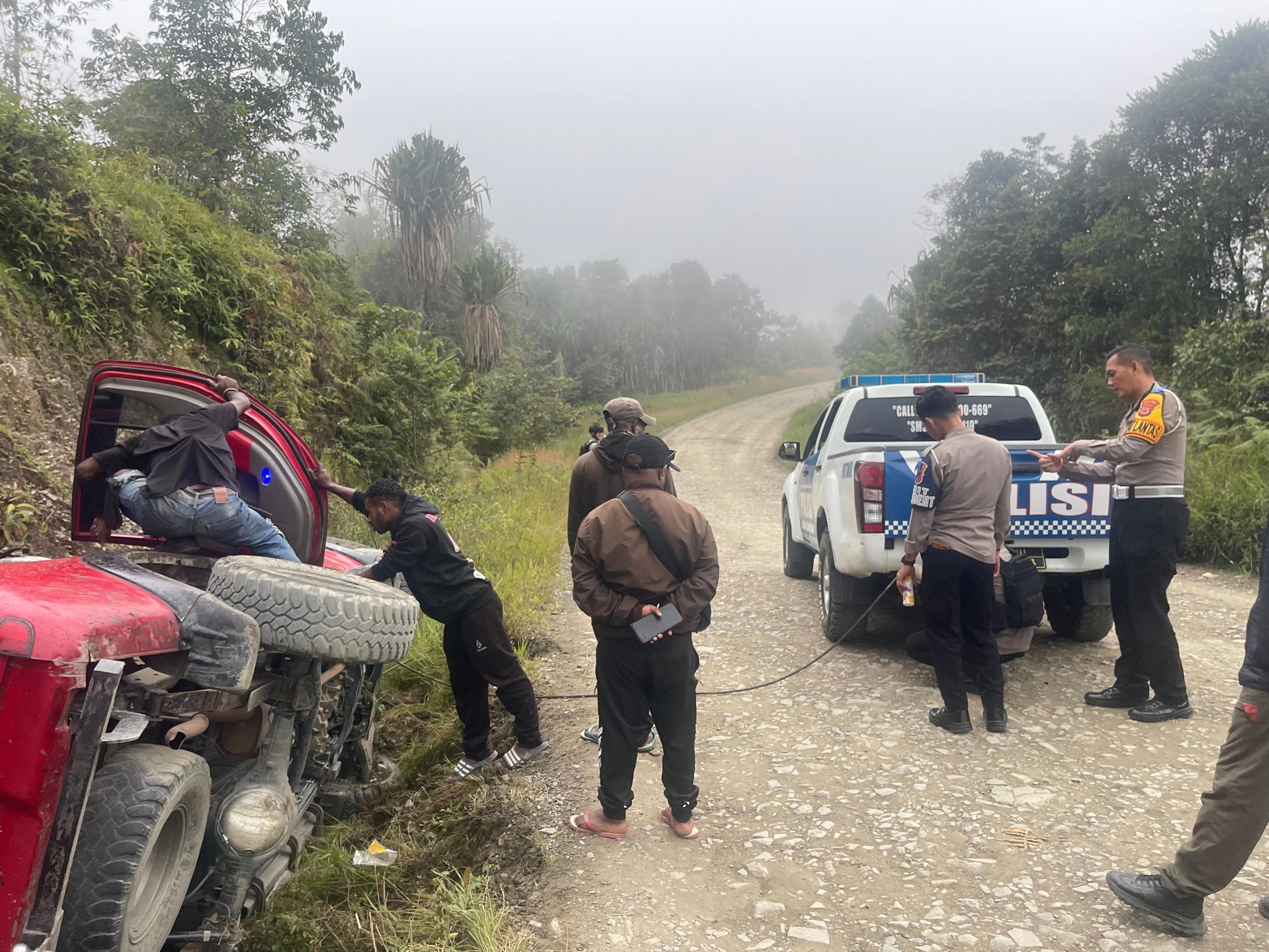 Ops Patuh Cartenz – 2025, Sat Lantas Polres Tolikara Berikan Bantuan Terhadap Kendaraan Roda 4 Yang Masuk Selokan Jalan