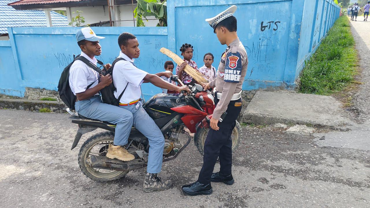 Sat Lantas Polres Tolikara Laksanakan Strong Point Pagi : Layani Penyeberangan Siswa Dan Bagikan Bendera Merah Putih Dalam Rangka HUT RI Ke – 80