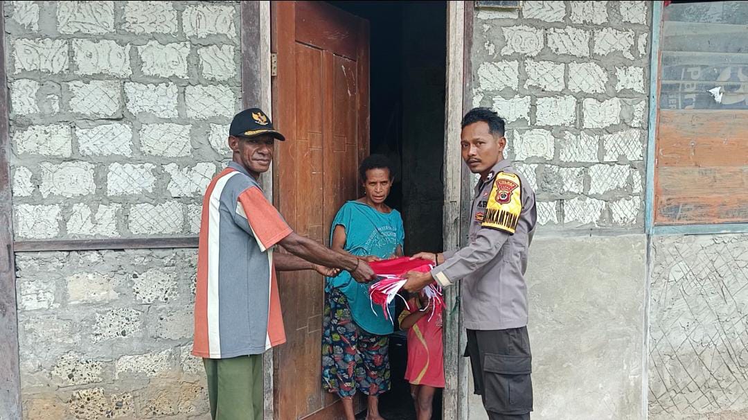 Sambut HUT RI ke-80, Bhabinkamtibmas Polsek Kouh Bagikan Bendera Merah Putih ke Warga Kampung Mandobo