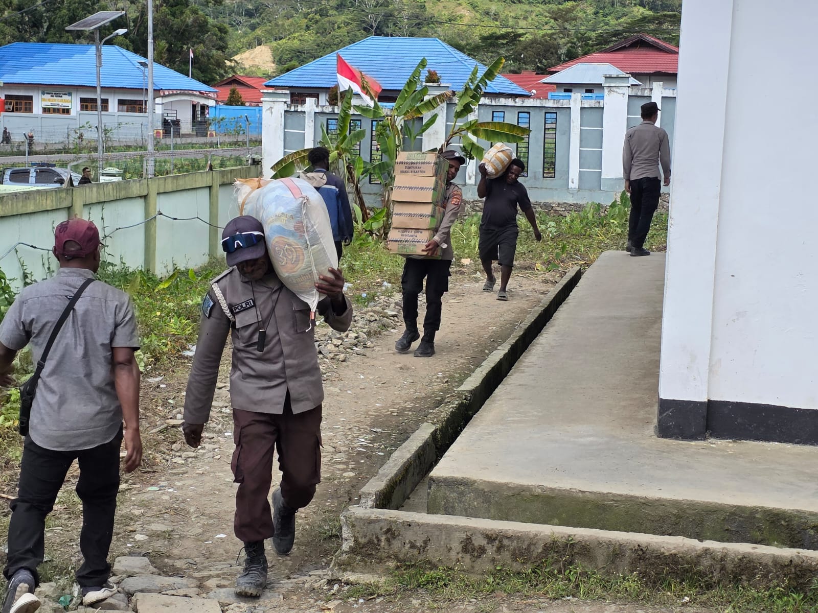 Anggota Polres Tolikara Bantu Distribusi Bantuan Dinas Sosial Provinsi Papua Pegunungan ke Posko Induk